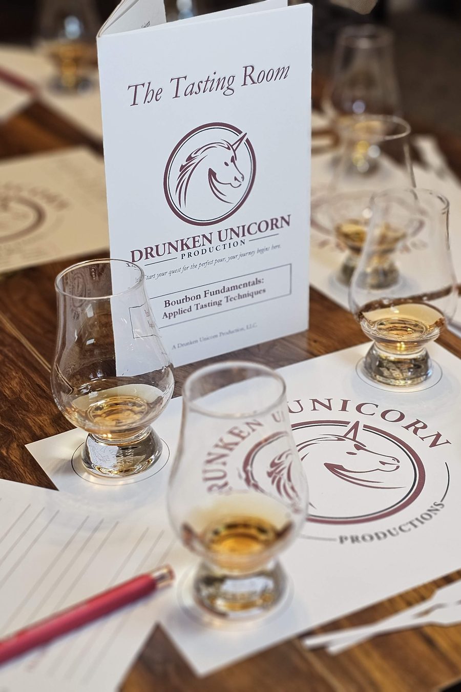 A Drunken Unicorn tasting table: the glasses, the tasting mat and The Tasting Room booklet